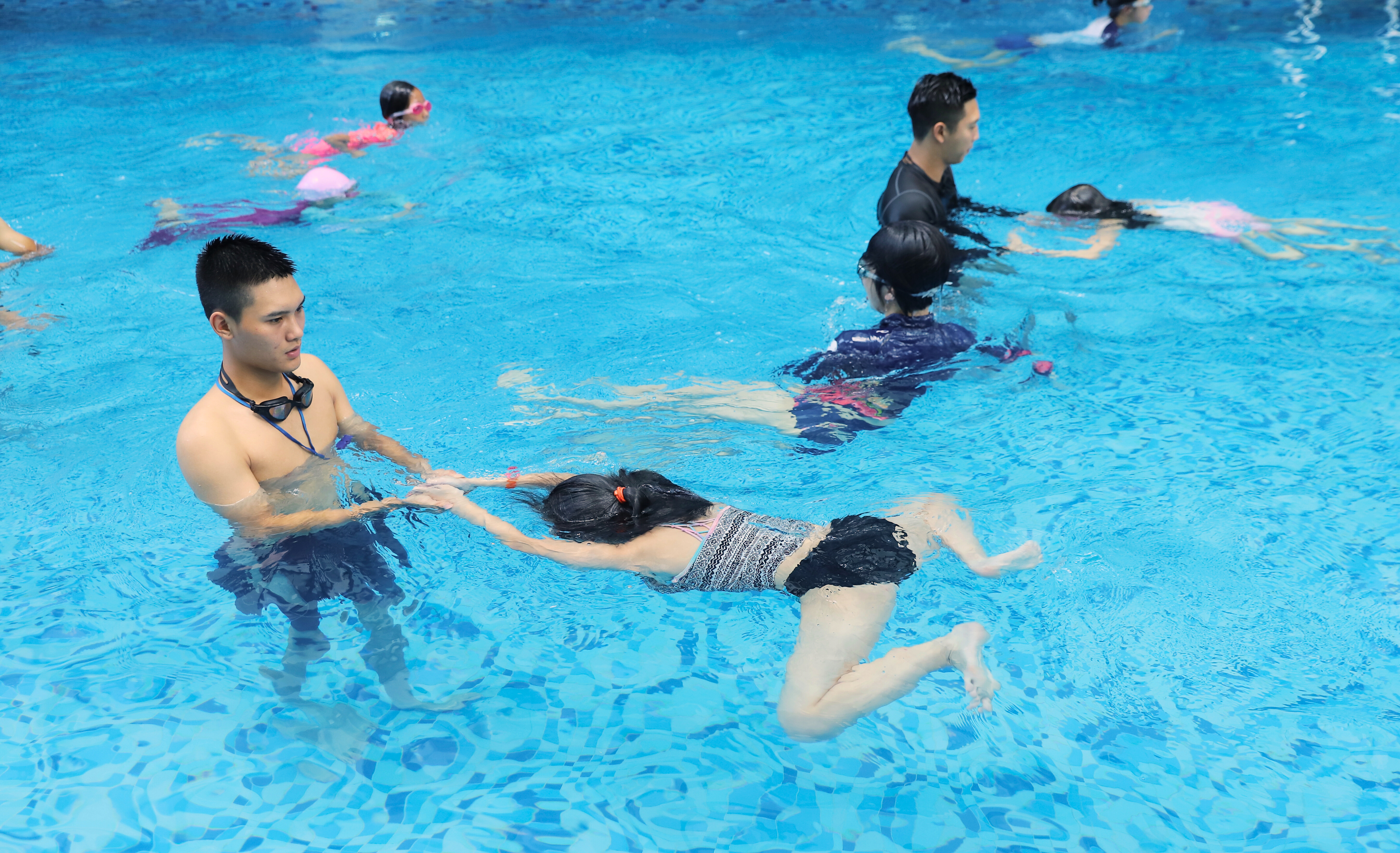 HLV Swim For Life hỗ trợ học viên tập đứng nước bằng chân ếch ở bể sâu